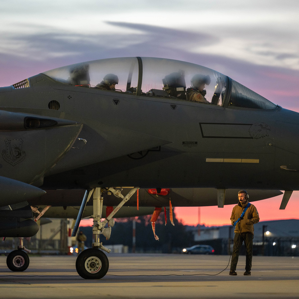 Man standing in front of military jet