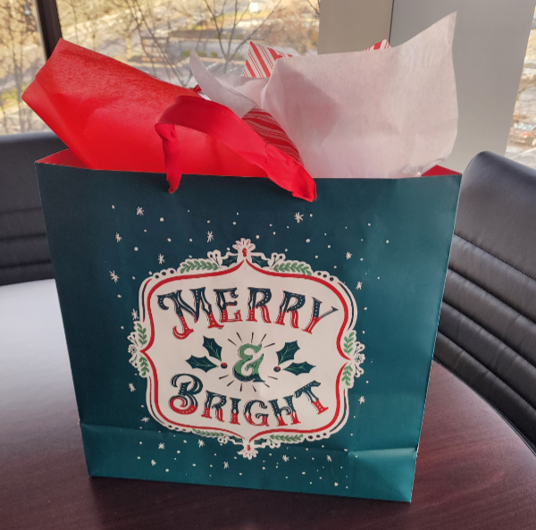 A festive gift bag with the words Merry & Bright