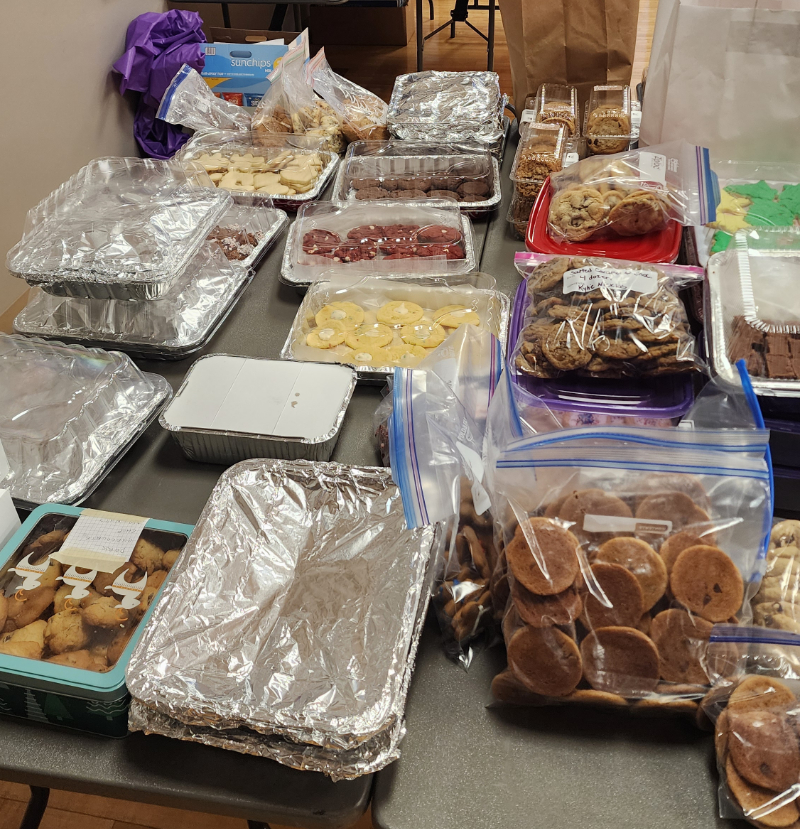 A table full of various types of cookies packaged up for the cookie sale