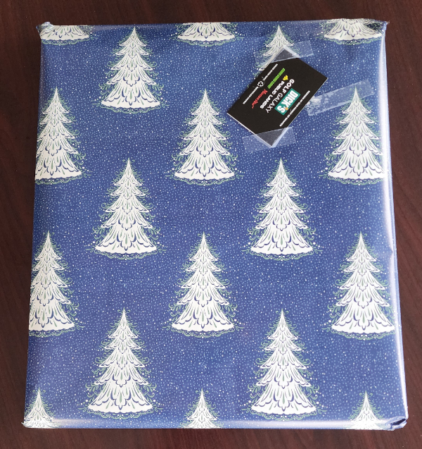 A gift wrapped in paper with a snowy winter tree pattern