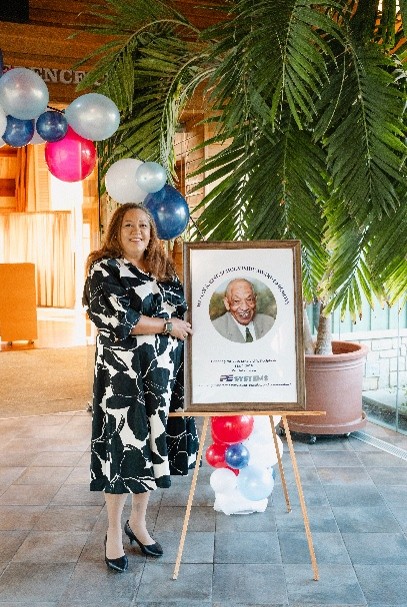 Marissa King beside Mr. Wesley A. King's [picture frame. 